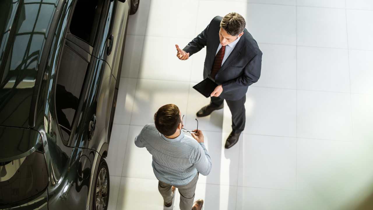 Un venditore di auto parla con un suo cliente