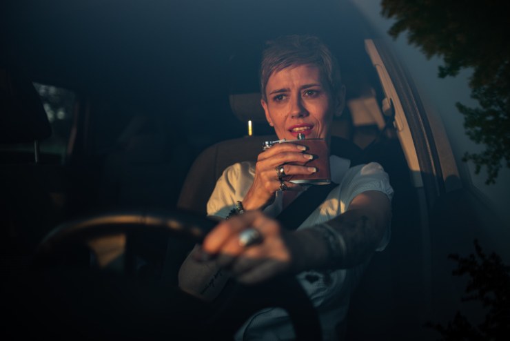 Una donna alla guida mentre beve